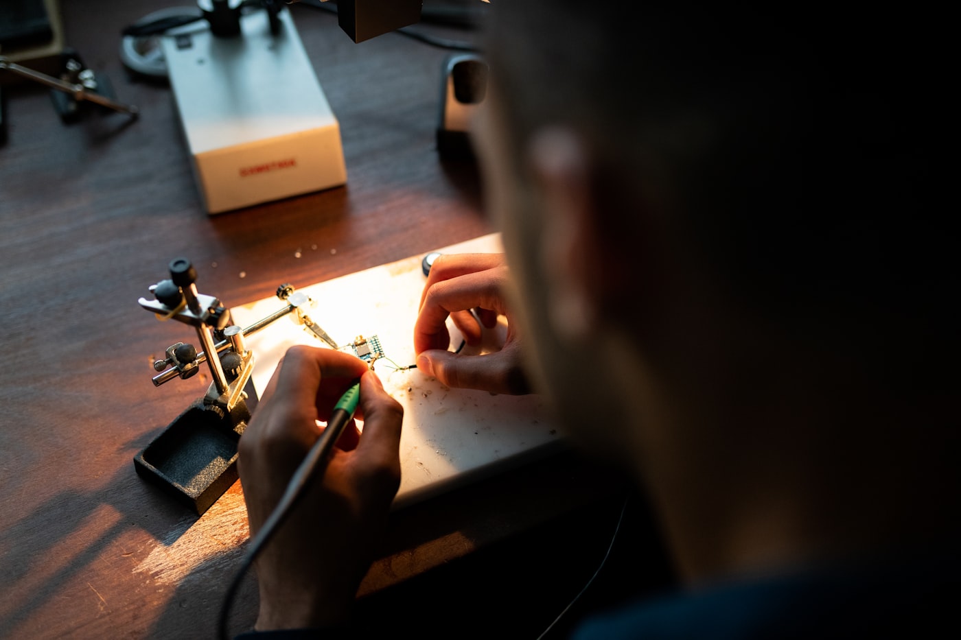 Técnico fazendo micro-soldagem com estação profissional