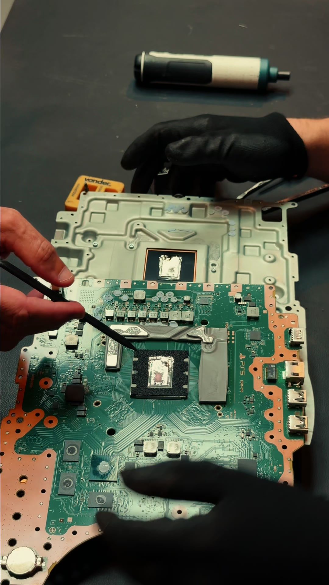 Placa de PS5 aberta na bancada da Mundo Joy